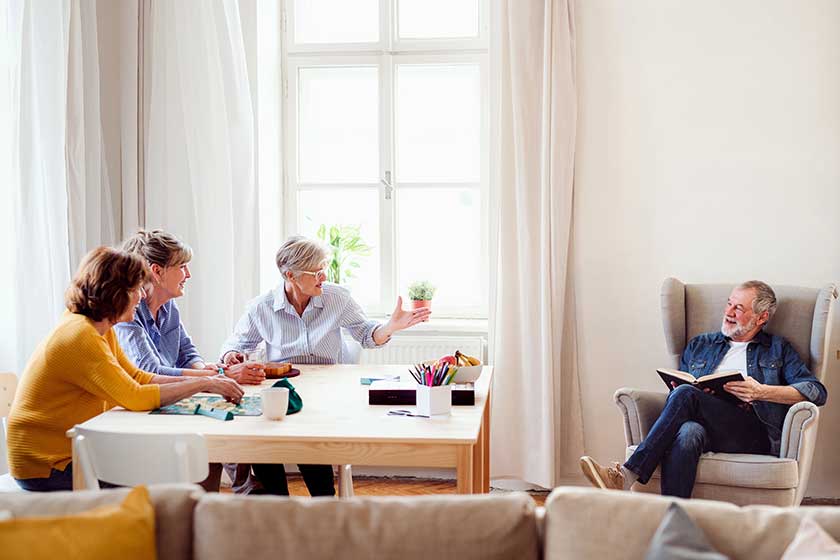 Group of senior people playing board games in community center club