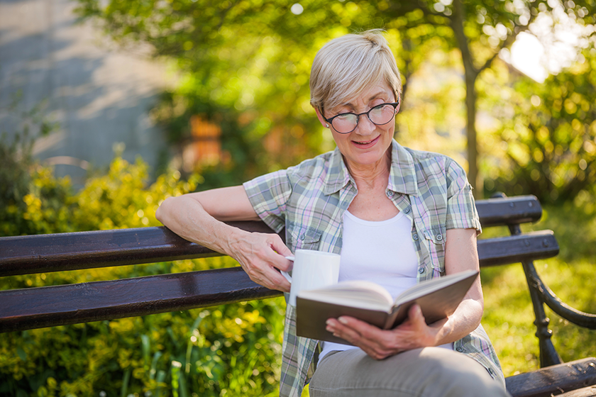 Happy senior woman enjoys reading book