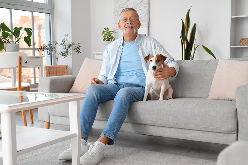 Mature man with cute Jack Russell terrier sitting