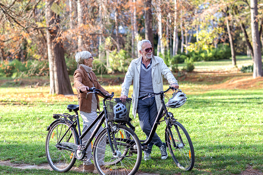 Old woman and man in park with bikes 